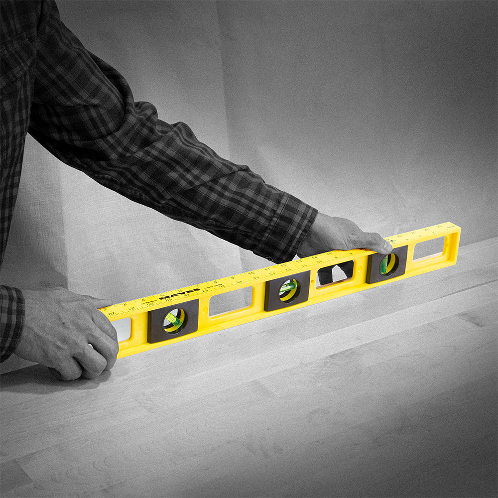 Black and white image of someone using a Mayes level where only the level is colored.